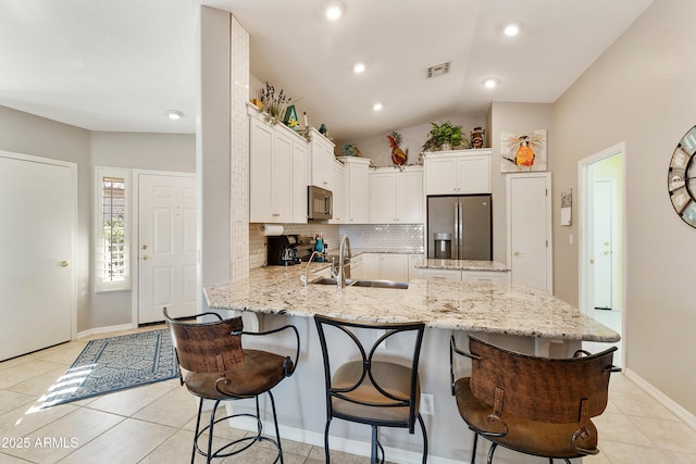 4674 E Alfalfa Dr, Gilbert, AZ 85298 - kitchen with black microwave, a peninsula, a sink, a kitchen breakfast bar, and stainless steel fridge