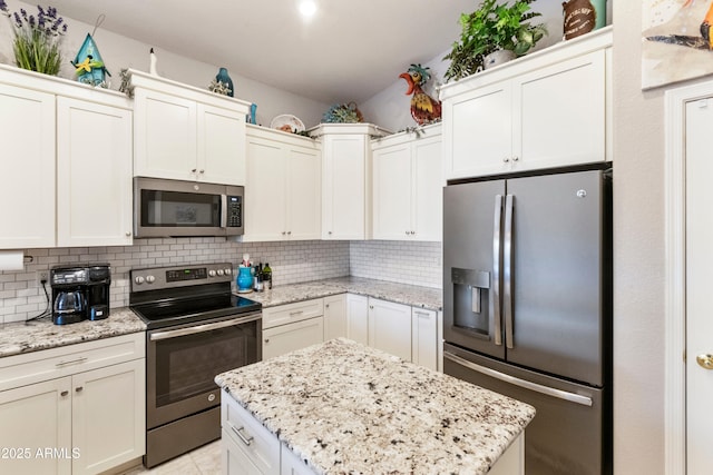 4674 E Alfalfa Dr, Gilbert, AZ 85298 - kitchen featuring appliances with stainless steel finishes, backsplash, light stone counters, and a center island