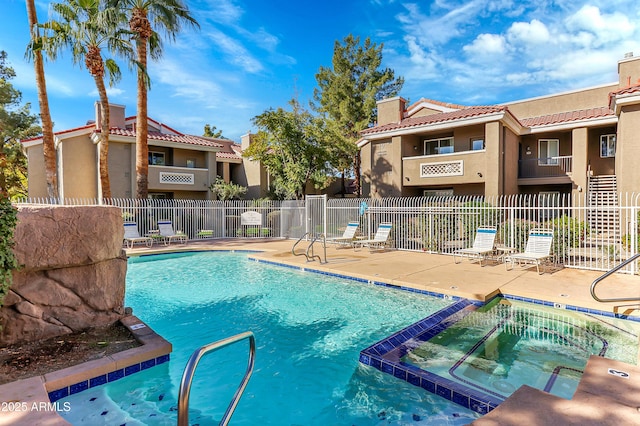 view of swimming pool featuring a patio area and a hot tub