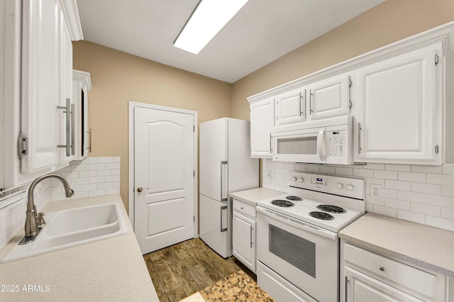 kitchen with backsplash, white appliances, sink, white cabinets, and dark hardwood / wood-style floors