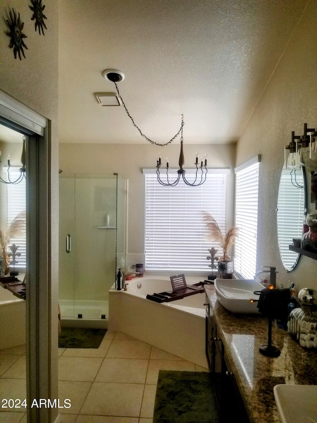 bathroom with vanity, independent shower and bath, a textured ceiling, and tile patterned flooring