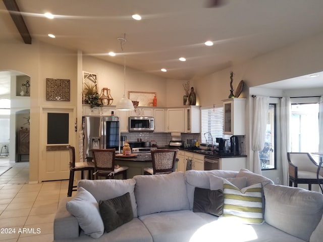 tiled living room featuring lofted ceiling with beams and sink