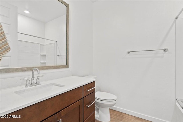 full bath featuring walk in shower, wood finished floors, vanity, baseboards, and toilet