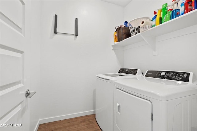 laundry room with laundry area, baseboards, wood finished floors, and washer and dryer