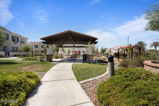 view of community featuring a gazebo, a yard, and a residential view