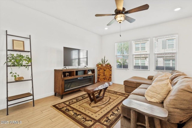 living area featuring recessed lighting, baseboards, a ceiling fan, and light wood finished floors