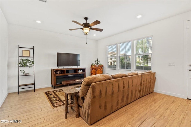 living room featuring recessed lighting, baseboards, a ceiling fan, and light wood-type flooring