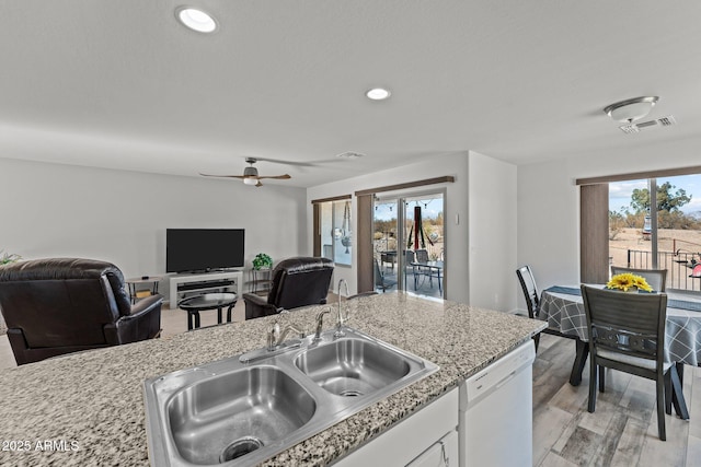 kitchen with white dishwasher, sink, a healthy amount of sunlight, and white cabinetry