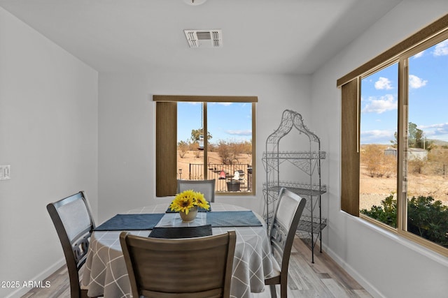 dining room featuring light wood-type flooring and a wealth of natural light