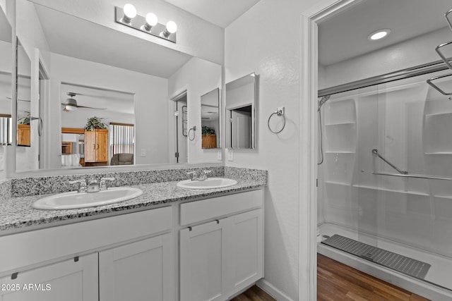 bathroom with an enclosed shower, vanity, hardwood / wood-style floors, and ceiling fan