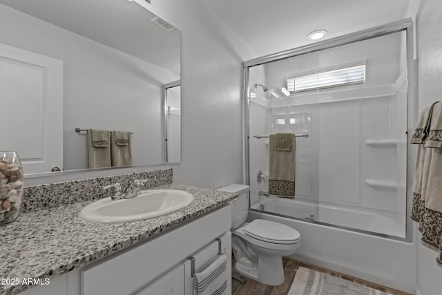 full bathroom featuring shower / bath combination with glass door, vanity, and toilet