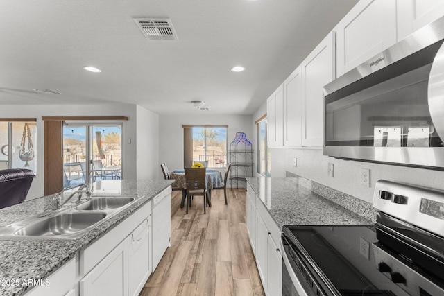 kitchen featuring appliances with stainless steel finishes, light hardwood / wood-style floors, white cabinets, and sink