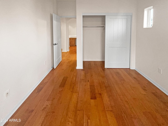 unfurnished bedroom with hardwood / wood-style floors and a closet