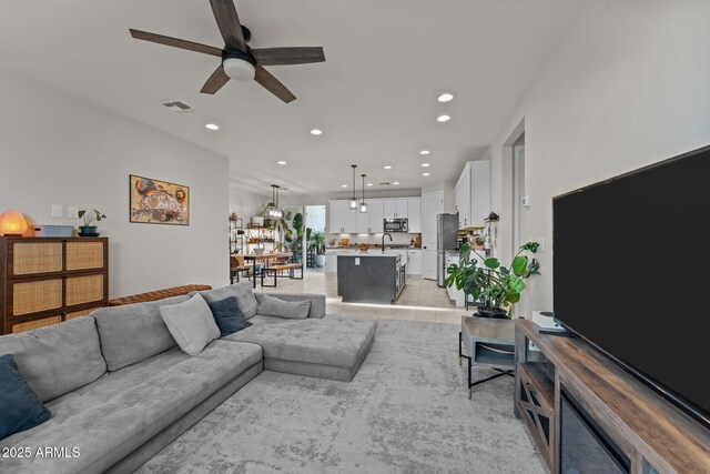living area featuring light tile patterned floors, a ceiling fan, visible vents, and recessed lighting