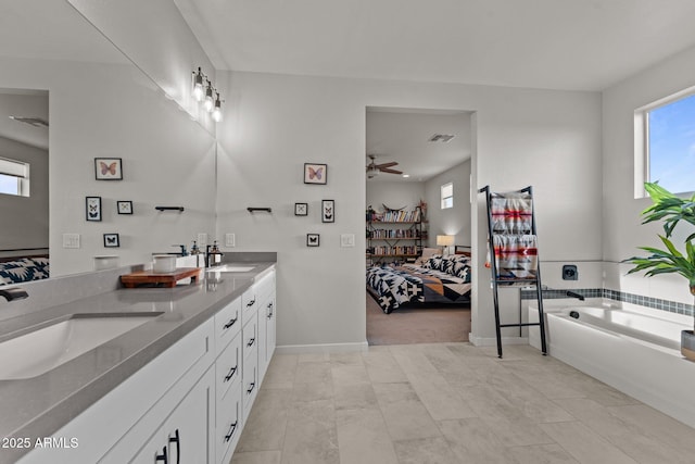 bathroom with a sink, ensuite bath, and a wealth of natural light