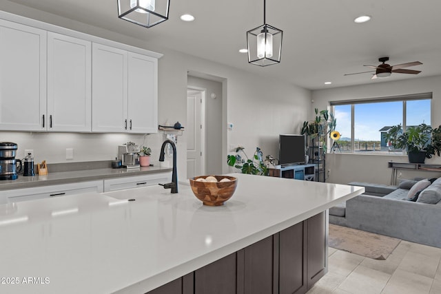 kitchen with open floor plan, a sink, white cabinetry, and recessed lighting