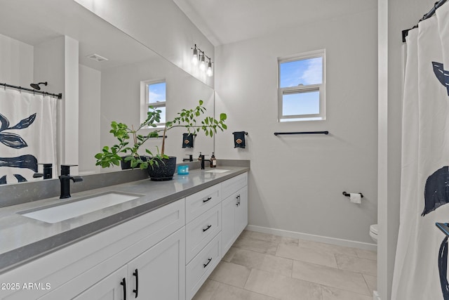 full bath with a sink, visible vents, toilet, and double vanity