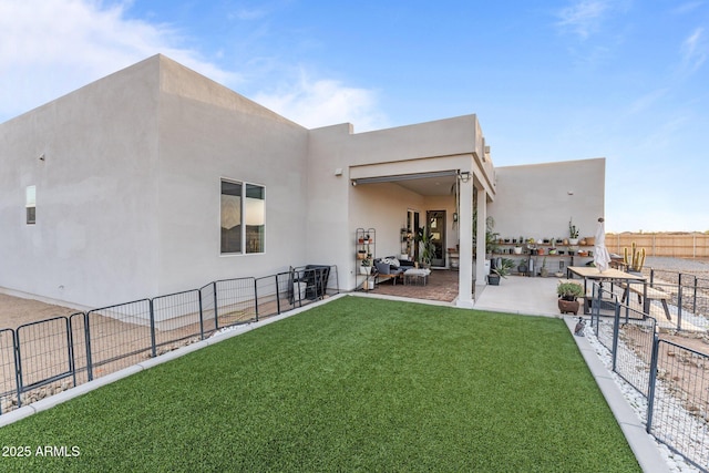 rear view of house with a patio area, fence, a lawn, and stucco siding