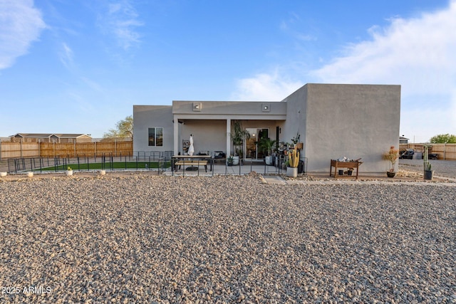 back of house featuring a patio, stucco siding, and fence