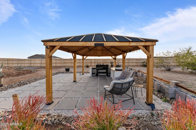 view of patio with area for grilling, a gazebo, and a fenced backyard