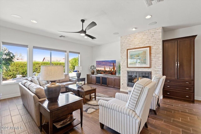 living room featuring a fireplace, ceiling fan, and a healthy amount of sunlight