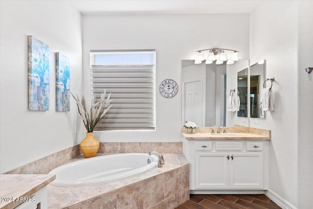 bathroom featuring vanity and tiled bath