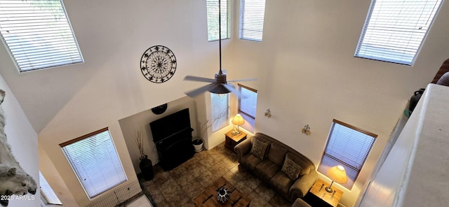 living room featuring ceiling fan and a towering ceiling