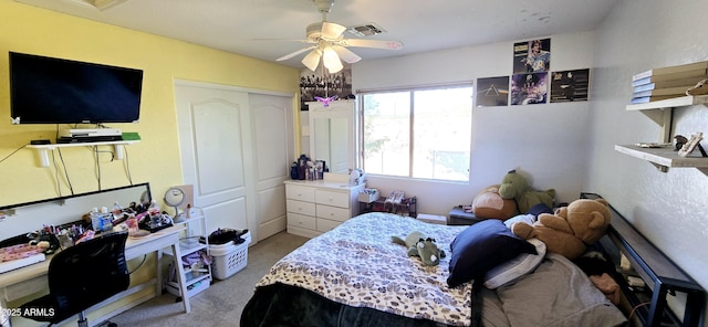 carpeted bedroom featuring visible vents, a closet, and a ceiling fan