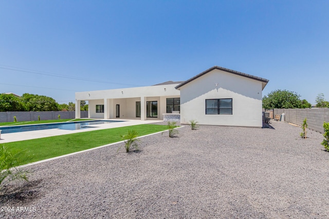 back of house featuring a fenced in pool and a patio area