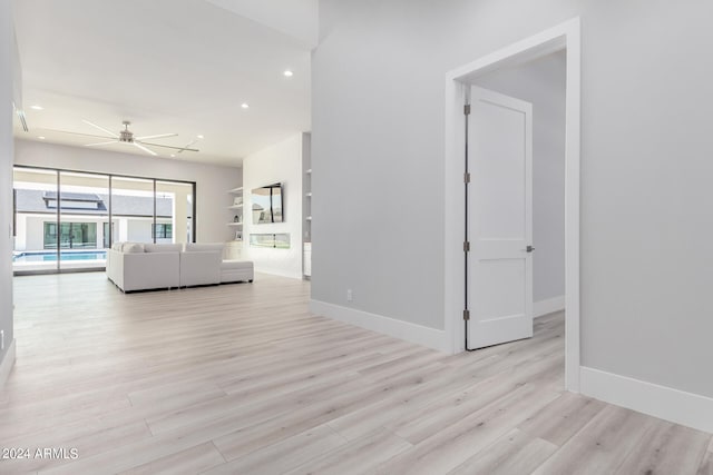 unfurnished living room featuring ceiling fan and light hardwood / wood-style flooring