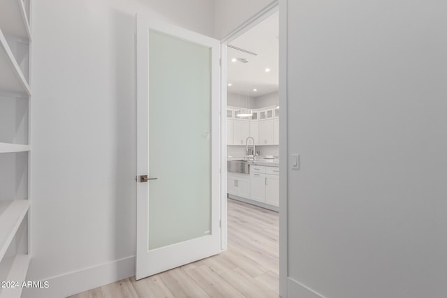 hall with sink and light hardwood / wood-style floors