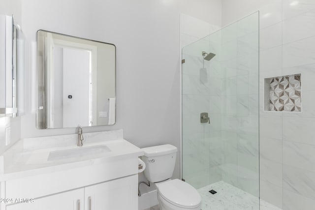 bathroom featuring an enclosed shower, vanity, and toilet