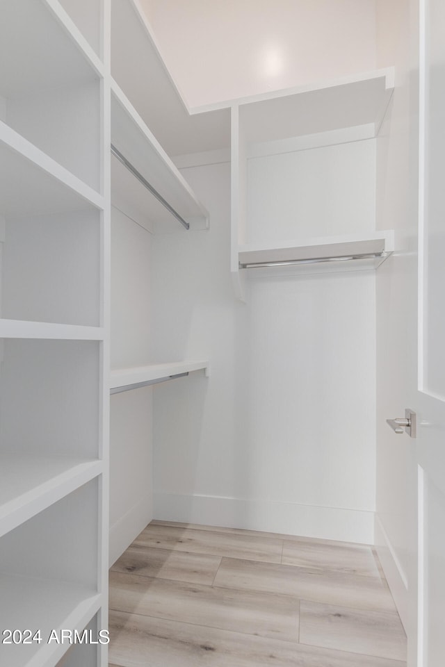 spacious closet with light hardwood / wood-style flooring