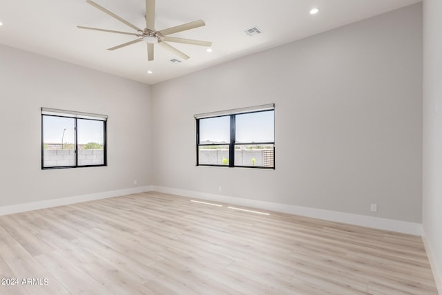 unfurnished room featuring ceiling fan, light hardwood / wood-style floors, and a healthy amount of sunlight