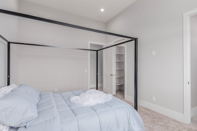 carpeted bedroom featuring a walk in closet