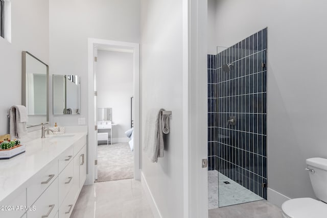 bathroom with a tile shower, vanity, and toilet