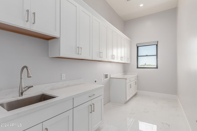 clothes washing area with electric dryer hookup, sink, washer hookup, and cabinets