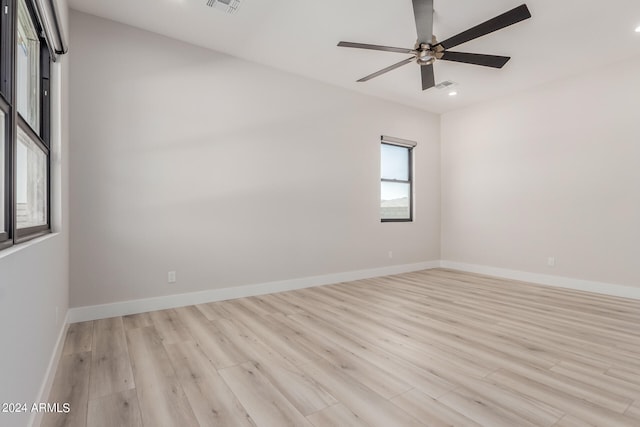 empty room with ceiling fan and light hardwood / wood-style flooring