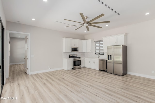 kitchen with light hardwood / wood-style floors, appliances with stainless steel finishes, sink, and white cabinetry