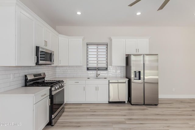 kitchen with stainless steel appliances, sink, and white cabinetry