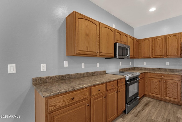 21616 E Calle De Flores, Queen Creek, AZ 85142 - kitchen featuring stainless steel appliances, dark countertops, light wood finished floors, and brown cabinets