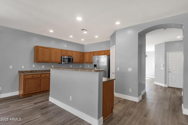 21616 E Calle De Flores, Queen Creek, AZ 85142 - kitchen with arched walkways, wood finished floors, stainless steel appliances, and a kitchen island