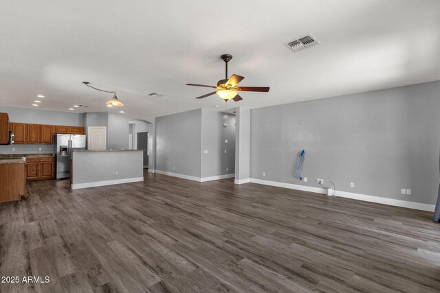 21616 E Calle De Flores, Queen Creek, AZ 85142 - unfurnished living room with dark wood-style flooring, visible vents, ceiling fan, and arched walkways