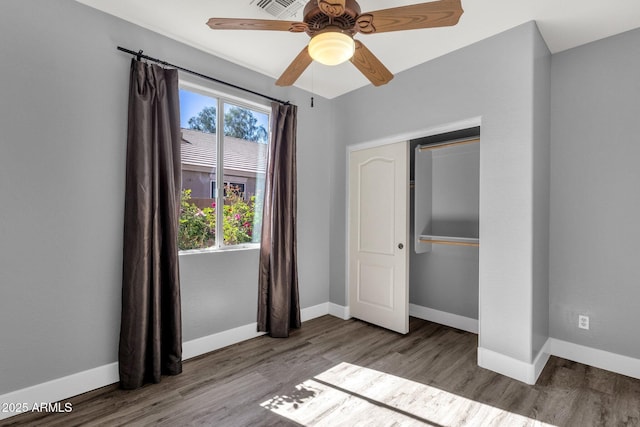 21616 E Calle De Flores, Queen Creek, AZ 85142 - unfurnished bedroom featuring baseboards, wood finished floors, a ceiling fan, and a closet