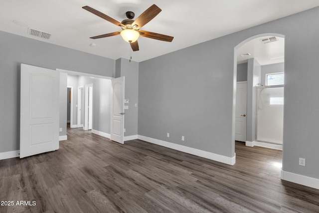 21616 E Calle De Flores, Queen Creek, AZ 85142 - unfurnished bedroom with baseboards, visible vents, arched walkways, and dark wood-type flooring
