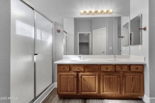 21616 E Calle De Flores, Queen Creek, AZ 85142 - bathroom with double vanity, wood finished floors, a shower stall, and a sink