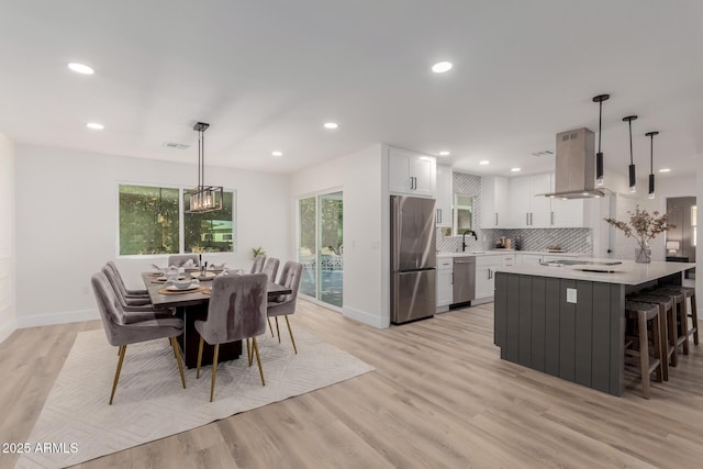 dining area with sink, a wealth of natural light, and light hardwood / wood-style flooring