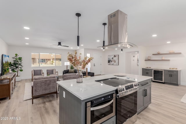 kitchen with gray cabinetry, stainless steel appliances, beverage cooler, and island range hood