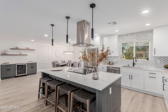 kitchen with white cabinetry, island exhaust hood, beverage cooler, and pendant lighting