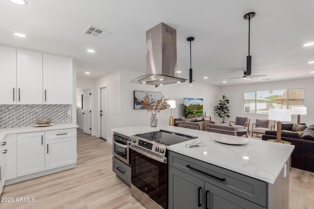 kitchen with white cabinetry, island exhaust hood, stainless steel electric range, and pendant lighting